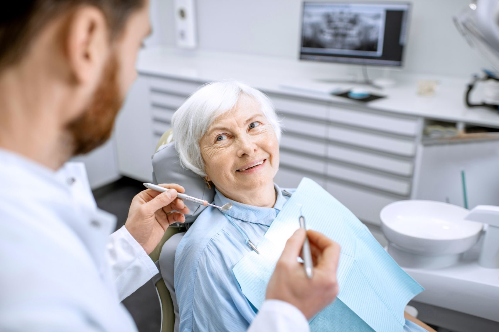 Zahnarzt im Gespräch mit einer Patientin